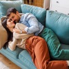 a couple laying down on a couch