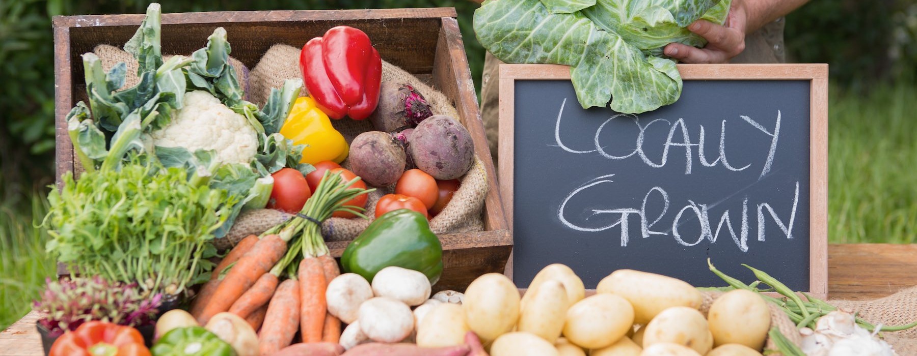 a person standing next to a table full of vegetables