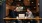 a two men sitting at a table with a laptop